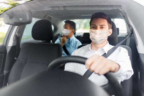 taxi driver in face protective mask driving car